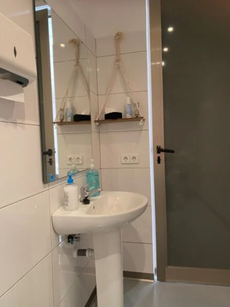 Waschbereich des barrierefreien Patienten-WCs - mit Hygieneartikeln und liebevollen Details für Ihr Wohlbefinden.