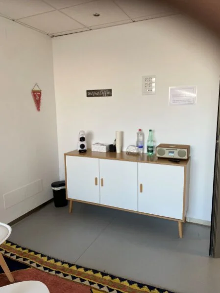 Kaffeebar mit Getränken, Teebox, Musikanlage und Snacks für Patienten.